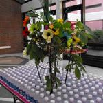 (Water Table Decor)
How do you make a bottled water table decorative and still functional? Like this! An iron stand with fresh tree branches intertwined with faux poppies stood within the perfectly aligned bottles of water. (Floral display available as a rental for your function) ~