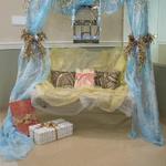 (Gift Swing)
The ceremonial swing was used as a gift area for this wedding. Draped in fabric, this area became a beautiful and functional display. Embellished pillows, card cage and prewrapped color coordinated gifts were added to create this unique presentation. ~
